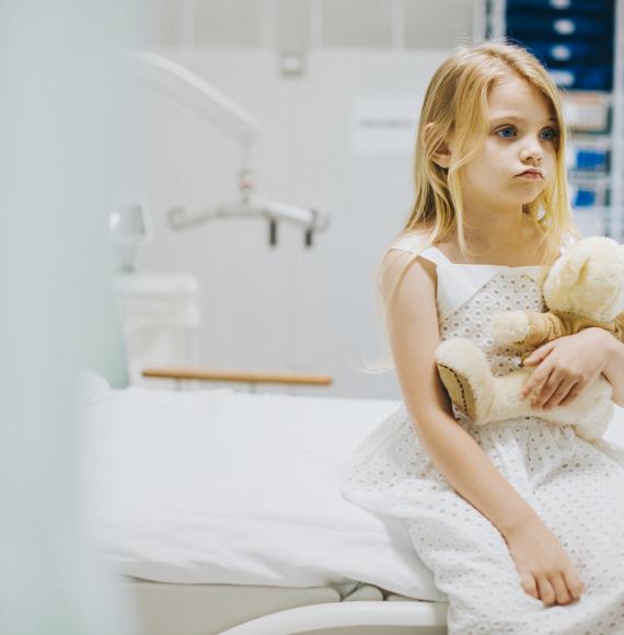 Child sitting on a hospital bed